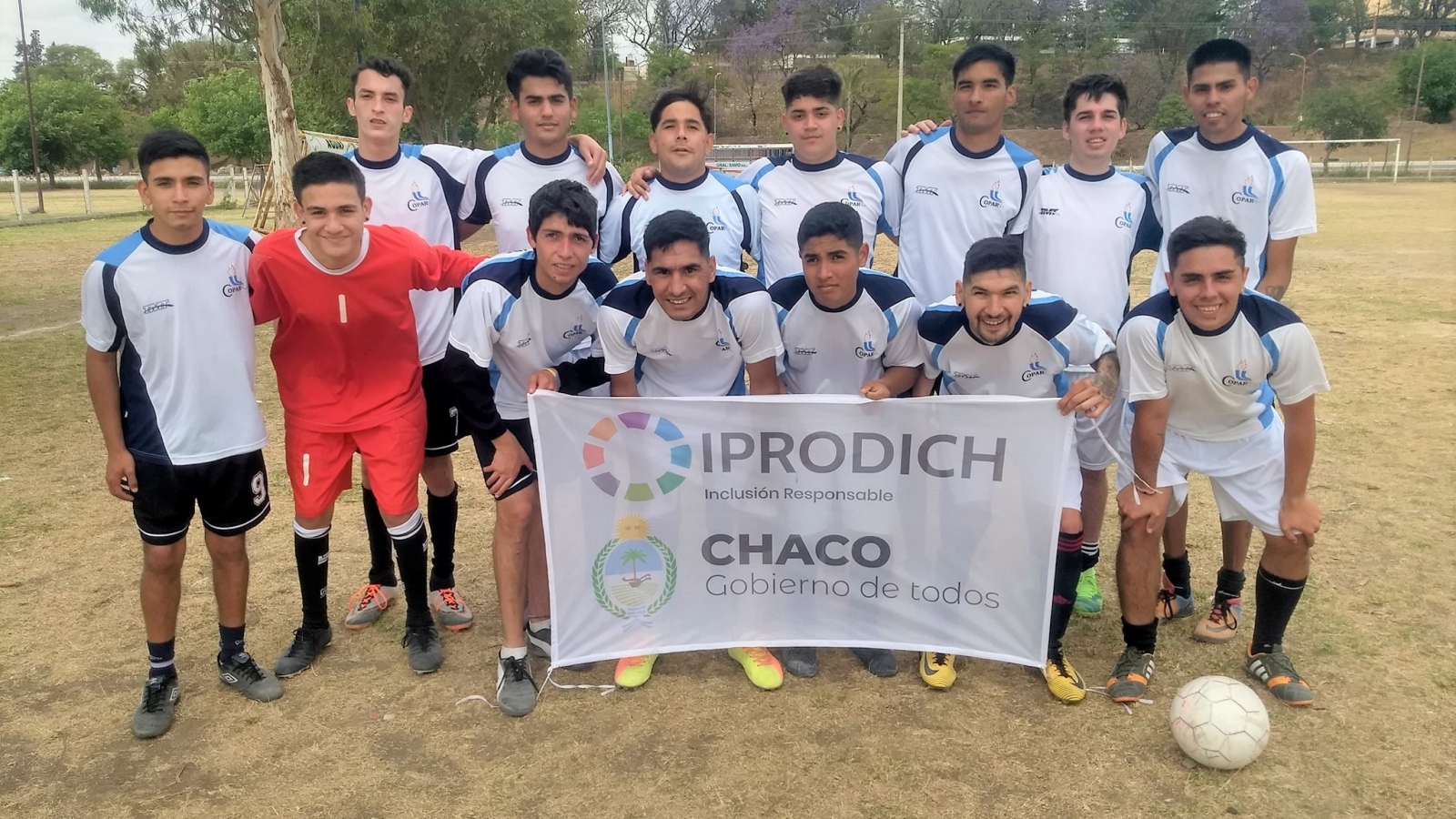 Equipo de fútbol posando para la foto con bandera del IPRODICH