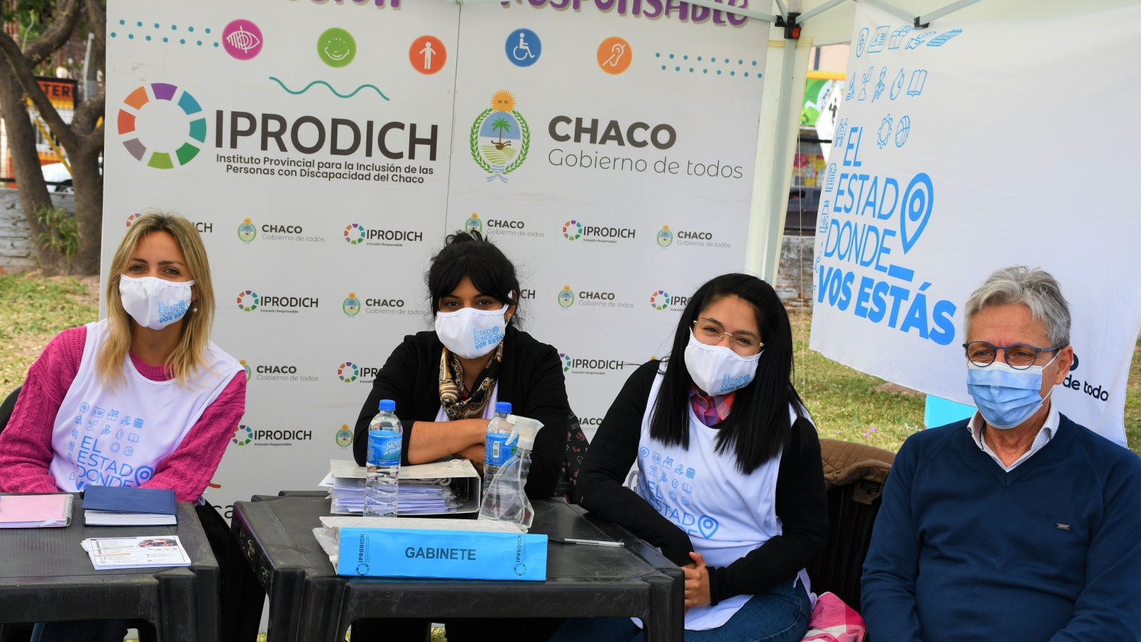 El presidente Lorenzo junto a trabajadoras del IPRODICH sonríen a cámara en el stand de El Estado donde vos estás