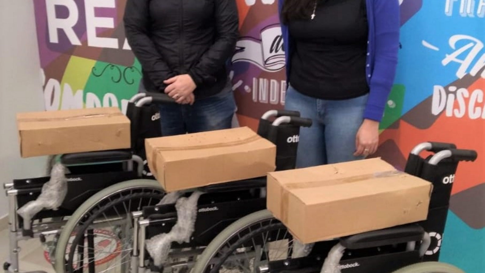 Trabajadores del IPRODICH entregando tres sillas de ruedas